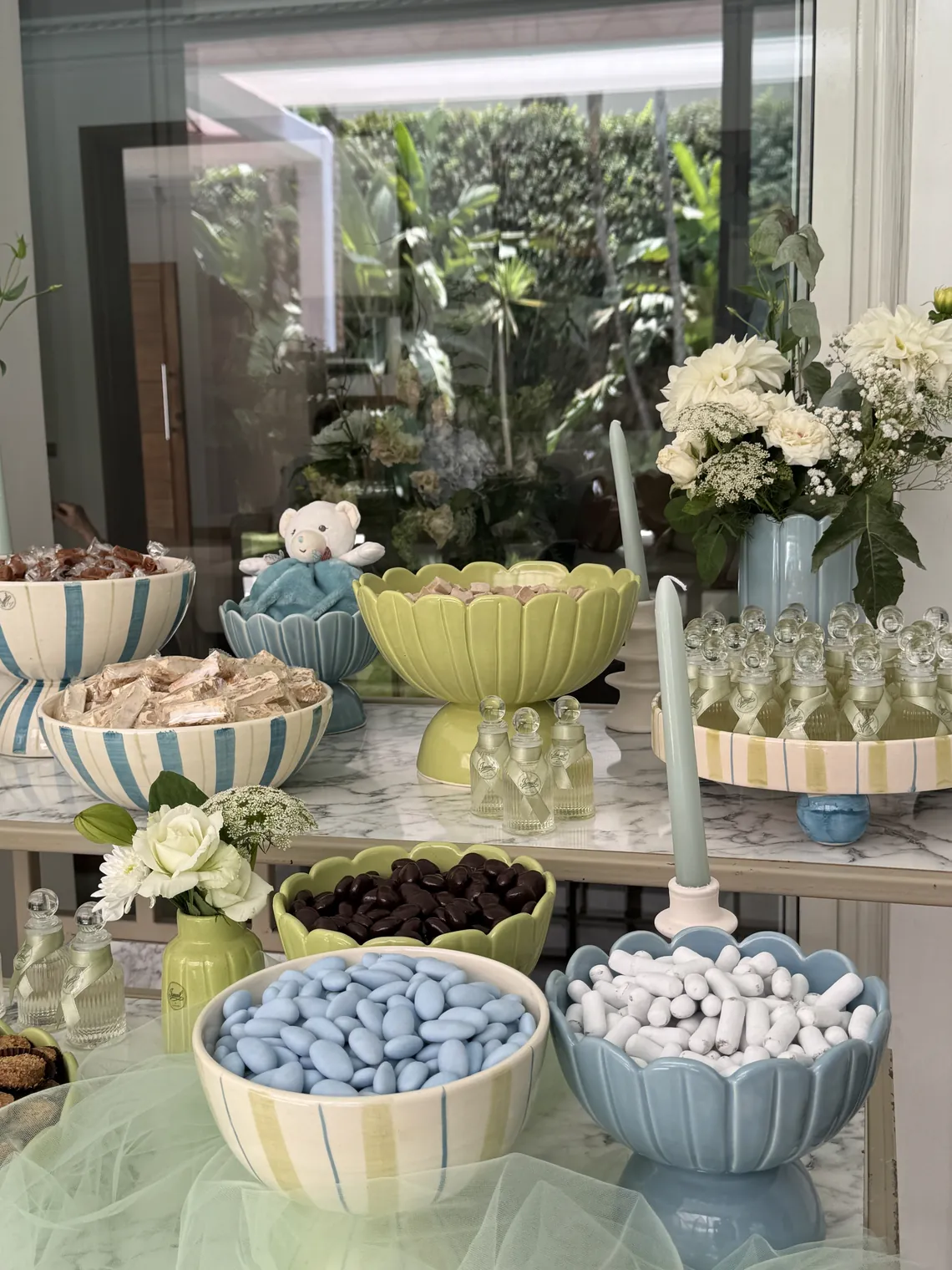 Buffet de naissance BEŶT, coupes sur pied et bols rayes en vert anis et bleu ciel sur un plateau de marbre